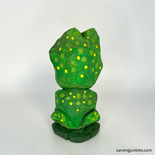 Back view of painted wooden frog carving