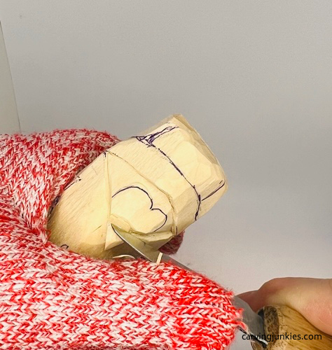 Cutting back wood on wood carved penguin