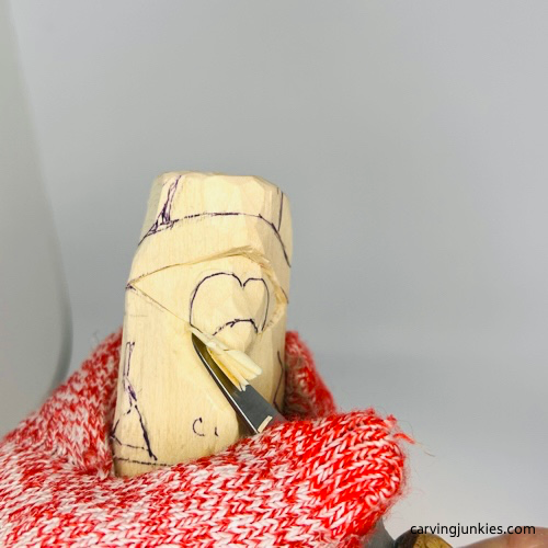 Removing wood on carved penguin