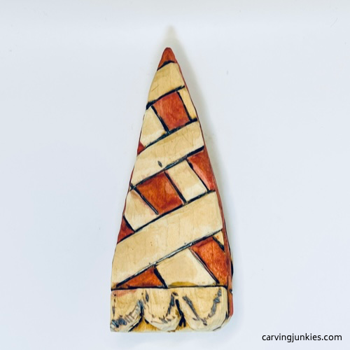 Top of painted wooden pie carving