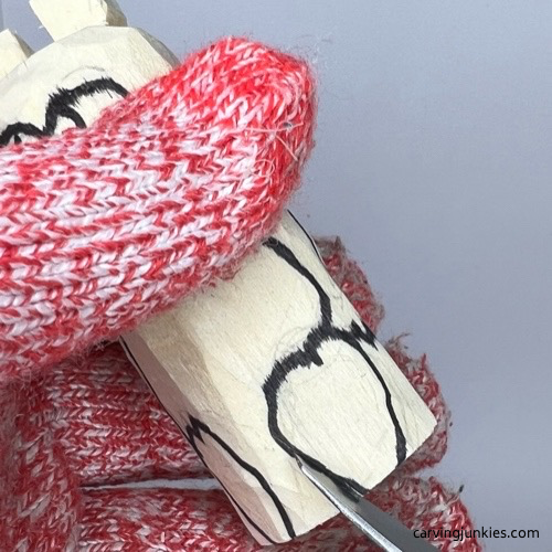 Carving hooves on wood pig