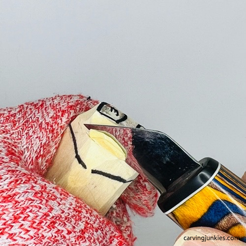 Cutting into ears on wooden pig