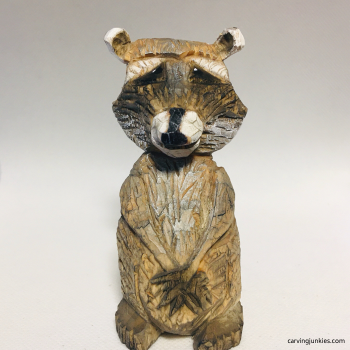 Painted wood carving of raccoon