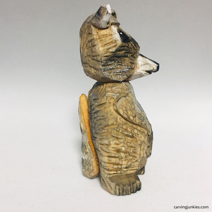 Side view of raccoon caricature carving
