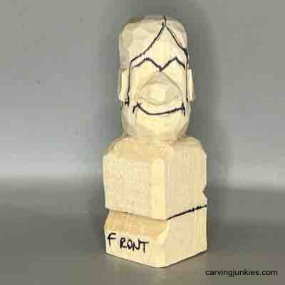 Make your own small wooden figure with our guide. Details sketched on face of small guy wood carving