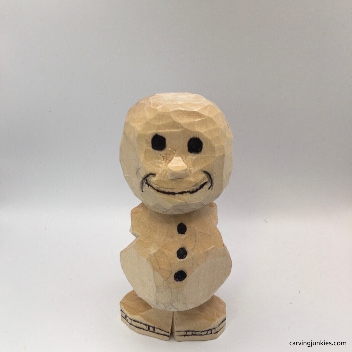 Face drawn on wood carved snowman