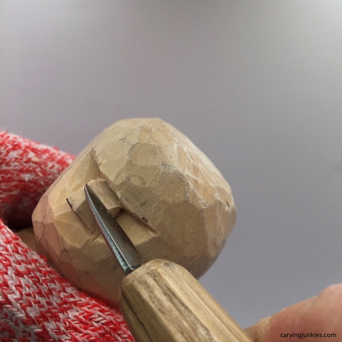 Carving top of wooden snowman nose