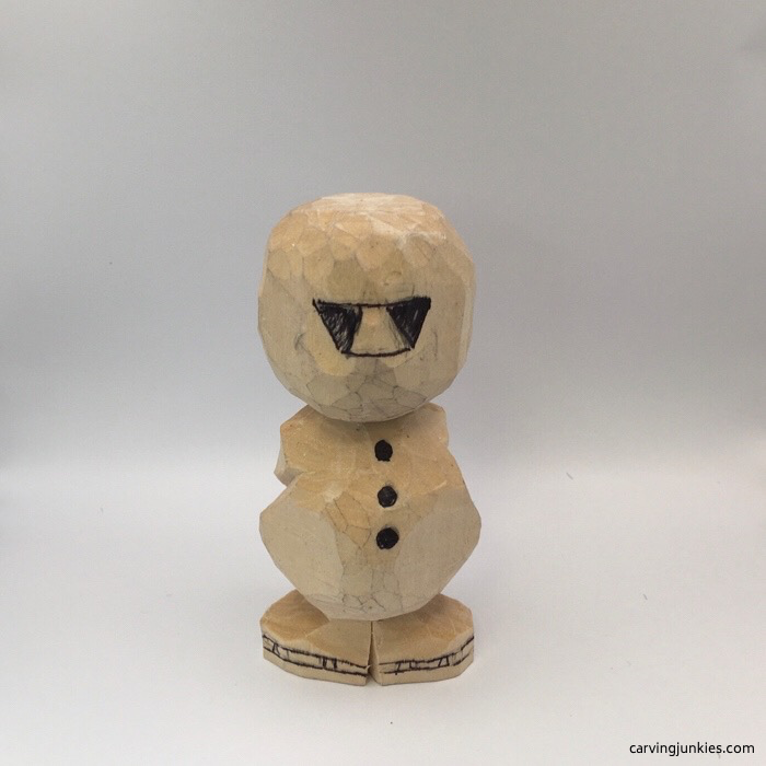 Drawn face of wood carved snowman