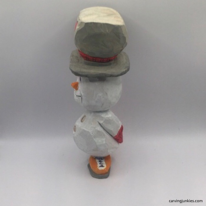 Left view of painted snowman wood carving