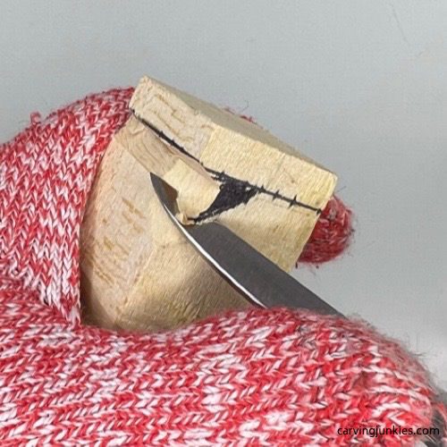 Cutting into legs on tiny wood carving man