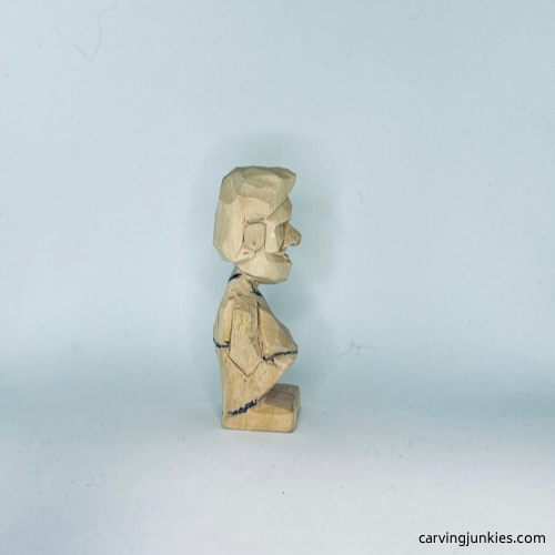 Clothes are sketched on right side of tiny wood carving man