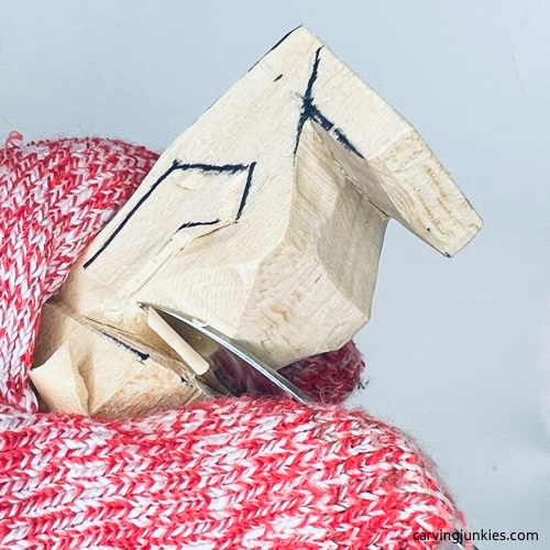 Cut into top of shoulder on tiny wood carving man