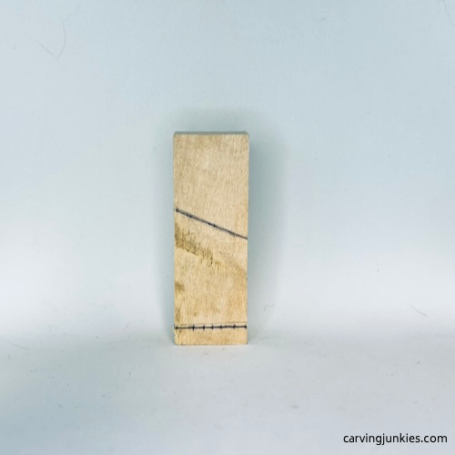 Guidelines on right side of tiny wood carving man