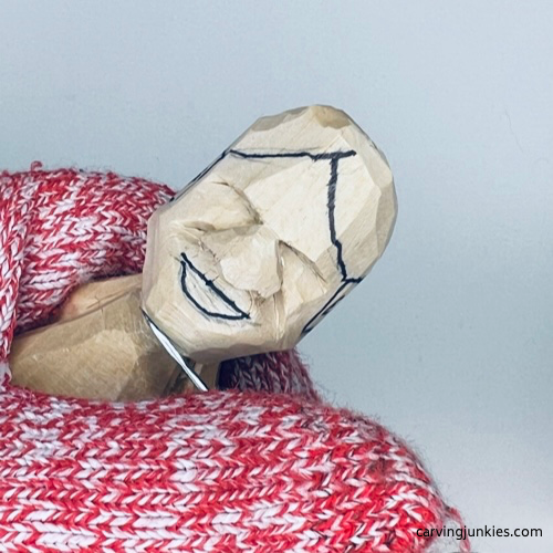 Carving chin on tiny wood carving man