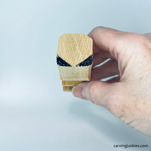 Top of tiny wood carving is marked for removal