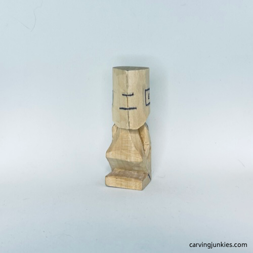 Front face guidelines on tiny wood carving man