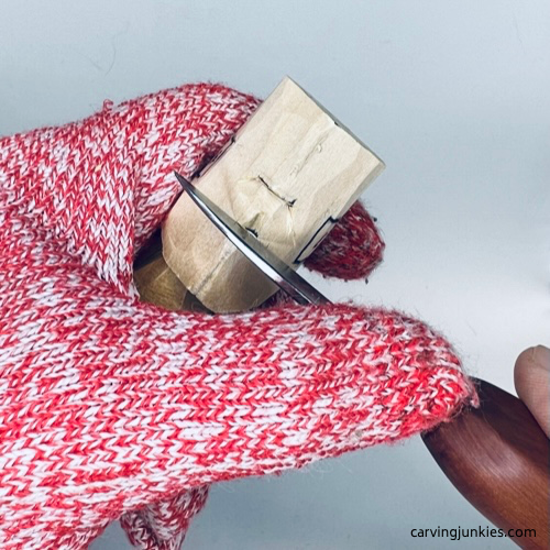 Making stop cut under nose on tiny wood carving man