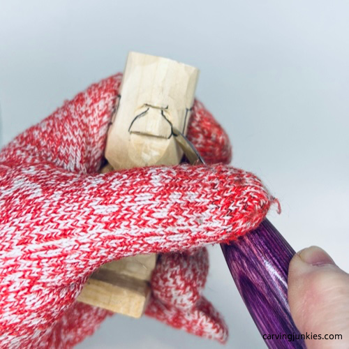 Carving nose on tiny wood carving man