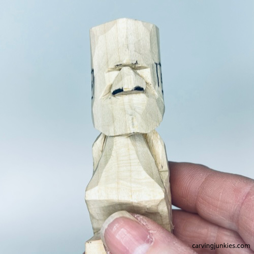 Nostrils are drawn on tiny wood carving man nose