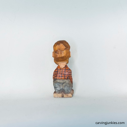 Painted back view of tiny wood carving man