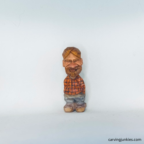 Painted front view of tiny wood carving man