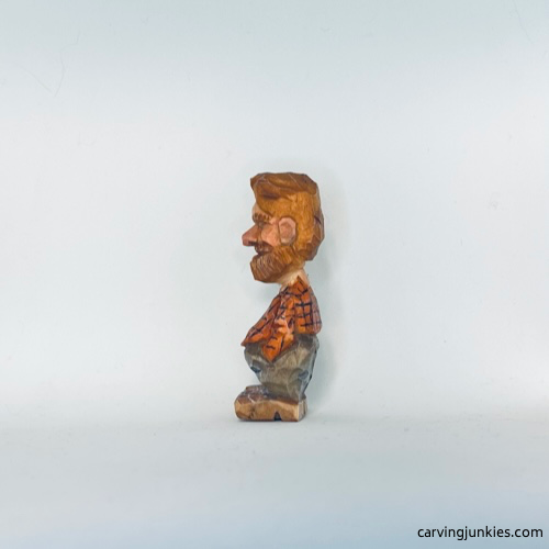 Painted left view of tiny wood carving man