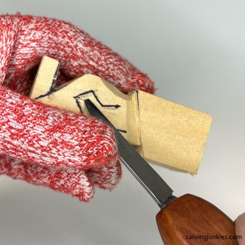 Making second slicing cut on tiny wood carving man