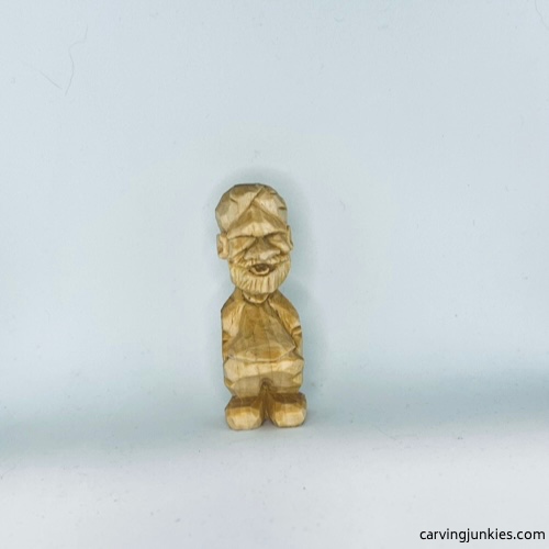 Front of unpainted tiny wood carving man