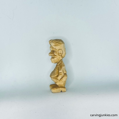 Left view of unpainted tiny wood carving man