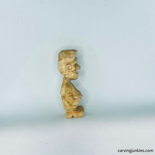 Right view of unpainted tiny wood carving man