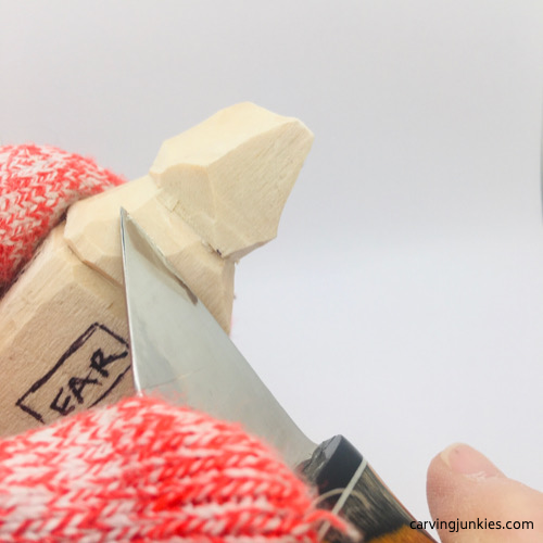 Cutting into hair on troll wood carving Shaping hair on troll wood carving