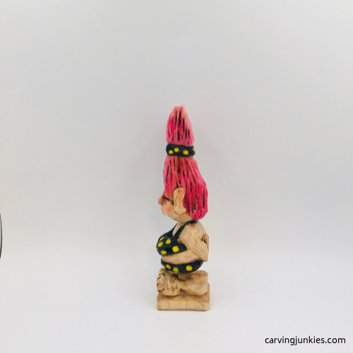 Left view of painted wooden troll Left side of painted troll carving