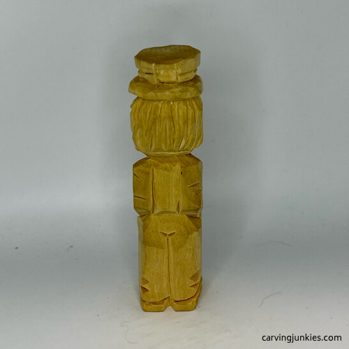 Back view of unpainted little man caricature carving