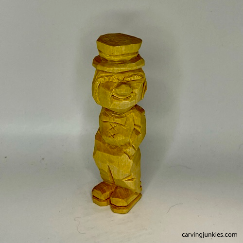 Front view of unpainted little man caricature carving
