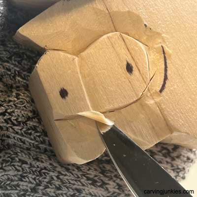 Carving eyes on a wooden fish