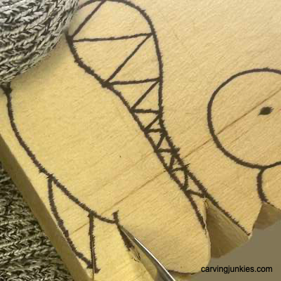 Carving away wood on fish whittling