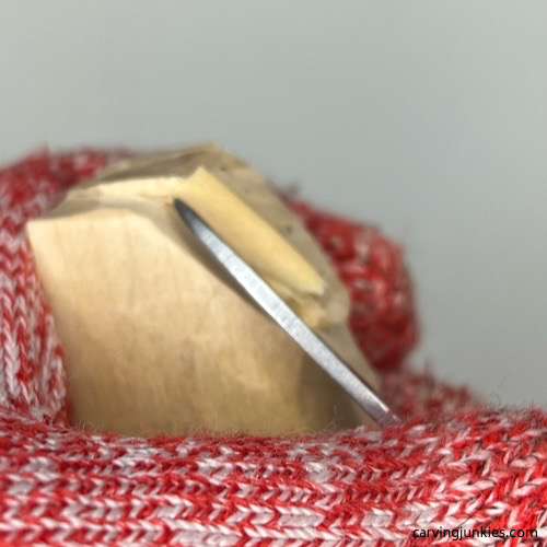 Shaping back of tail on cat whittling Shaping tail of whittled cat