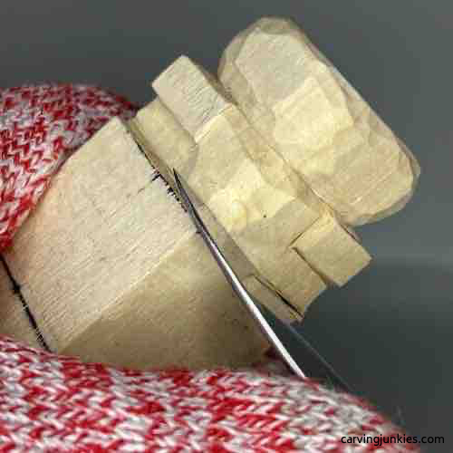 Starting to round rock on wooden Buddha