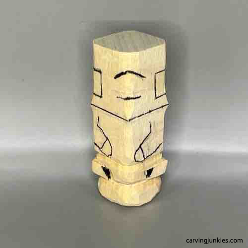 Facial details sketched on wooden Buddha 