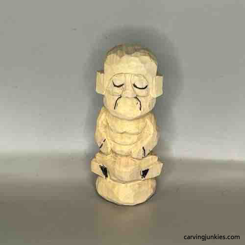 Frown lines are added to wood carved Buddha