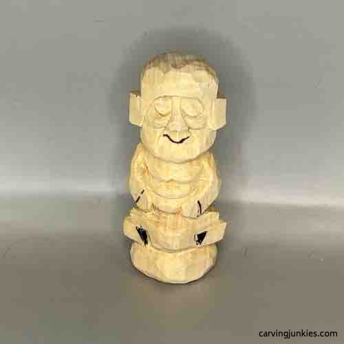 Mouth is sketched on wood carved Buddha