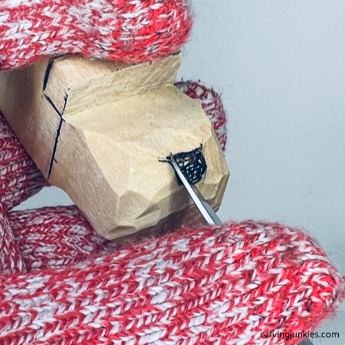 Snout of wood being carved to make an alligator