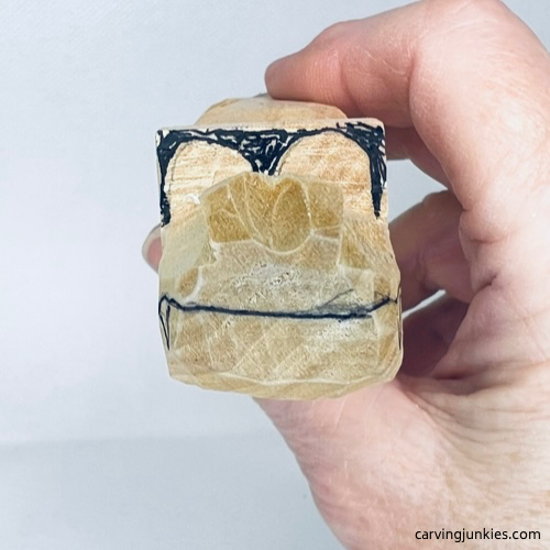 Guidelines on wood to guide how to carve eyes on a wooden alligator