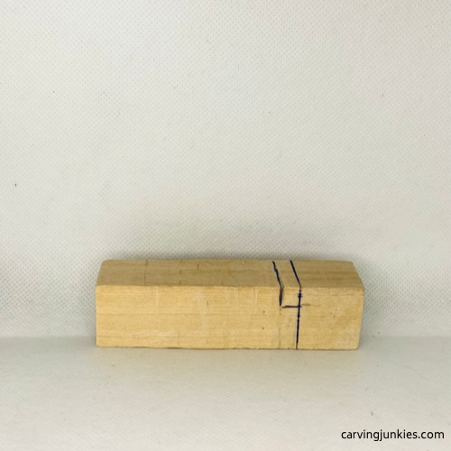 Eye guidelines sketched on wood to carve a funny alligator