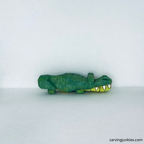 Right view of green painted wood carved alligator with big white teeth