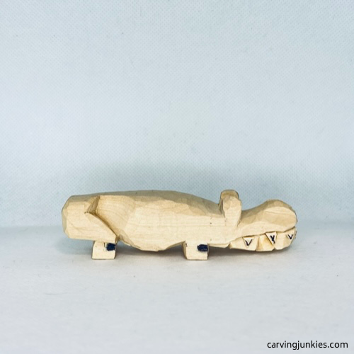 Marking wood for removal on feet on wood carved alligator