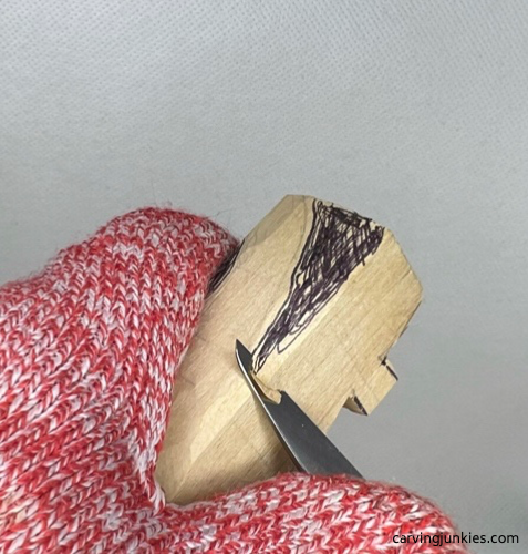 Slicing off wood to carve the tail on a wooden alligator