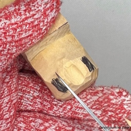 Shaping snout with a knife to carve an alligator