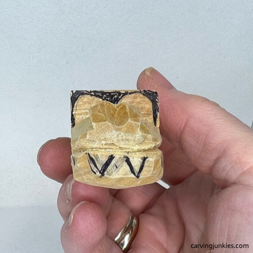 Front teeth sketched on wood to guide carving a wood alligator