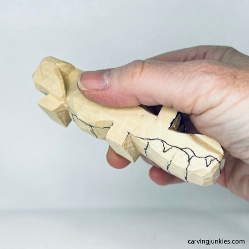 Big teeth are drawn to guide carving a funny wooden alligator